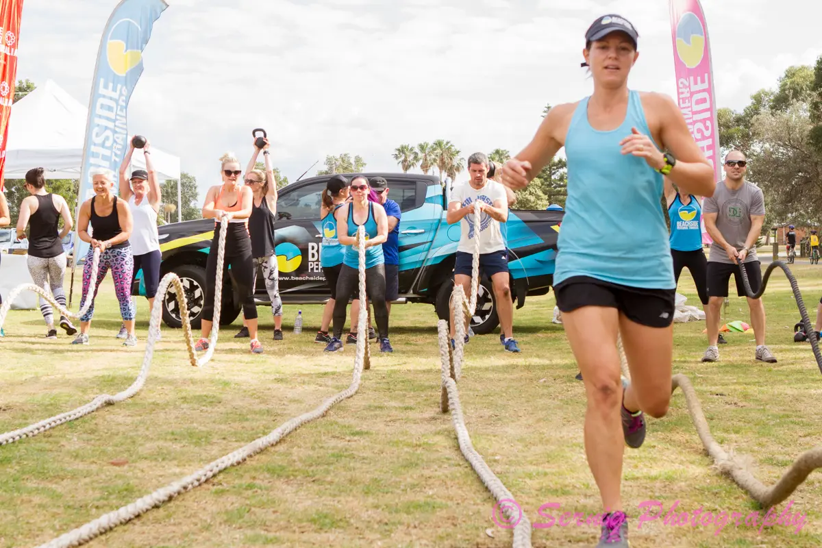 Running between battle ropes at a Beachside event